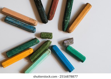 A collection of used, multi colored crayons or pastels arranged in a loose circular pattern on white background, likely for drawing or coloring. - Powered by Shutterstock