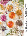 Collection of useful herbs for treatment according to folk recipes.medicinal herbal tea.wild medicinal herbs , cups of tea from Hypericum, oregano, fireweed, mint, celandine, chamomile. 
