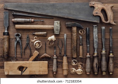 Collection of vintage carpentry tools on an old workbench: woodworking, craftsmanship and handwork concept, flat lay - Shutterstock ID 712183354