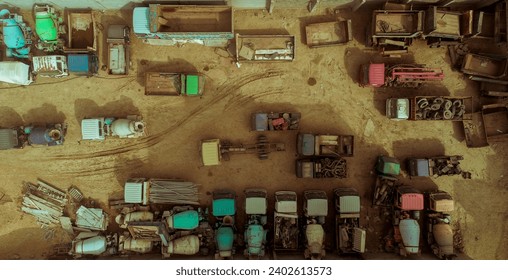 A collection of vintage trucks parked on a sandy beachfront in front of a coastal town, with colorful buildings in the background - Powered by Shutterstock