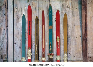 Collection of vintage wooden weathered ski's in front of an old barn