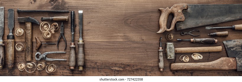Collection of vintage woodworking tools on a rough workbench and blank copy space: carpentry, craftsmanship and handwork concept, flat lay - Shutterstock ID 727422358