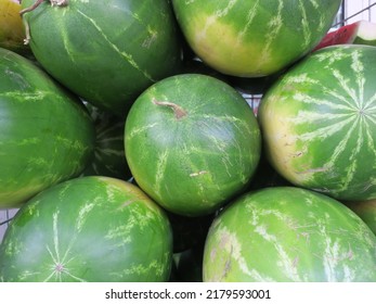 a collection of watermelons in front of a grocery store