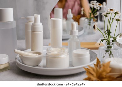 The collection of white skincare products on a tray for beauty and self-care routines.