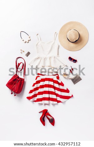collection of women's clothing and accessories. Overhead of essentials young woman. Outfit of casual and elegant woman, red shoes, summer hat, handbag, high heels shoes, sunglasses.