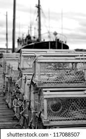 A collection of wooden lobster traps sit on a pier on Lunenburg, Nova Scotia