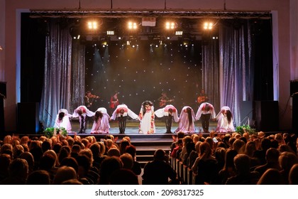 A collective of musicians, singers and dancers in gypsy costumes perform on stage. - Shutterstock ID 2098317325