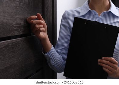 Collector with clipboard knocking on door indoors, closeup - Powered by Shutterstock