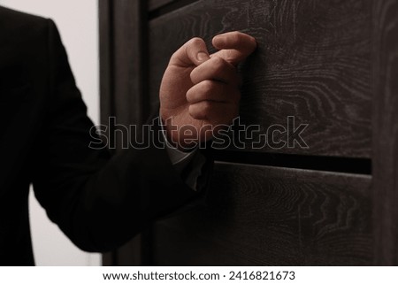 Collector knocking on door indoors, closeup view