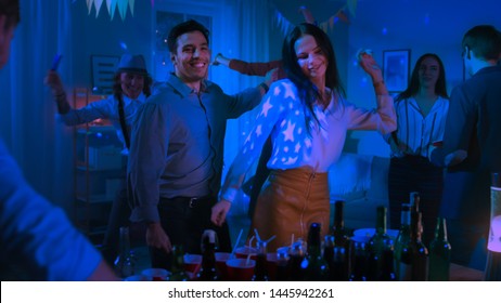 At The College House Costume Party: Diverse Group Of Friends Have Fun, Dance Off And Socializing And Drinking. Stylish Boys And Girls Dance Energetically In The Living Room. Disco Neon Lights.