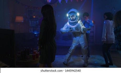 At The College House Costume Party: Fun Guy Wearing Space Suit Dances Off, Doing Robot Dance Modern Moves. With Him Beautiful Girls And Boys Dancing In Neon Lights.