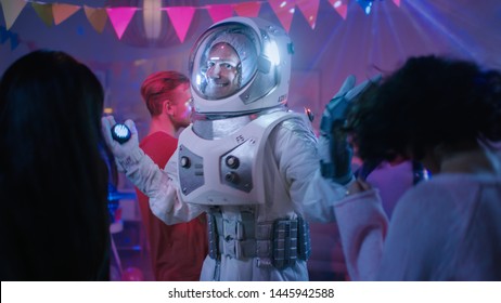 At The College House Costume Party: Fun Guy Wearing Space Suit Dances Off, Doing Robot Dance Modern Moves. With Him Beautiful Girls And Boys Dancing In Neon Lights.