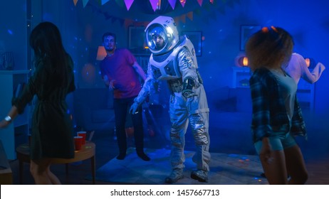 At The College House Costume Party: Fun Guy Wearing Space Suit Dances Off, Doing Robot Dance Modern Moves. With Him Beautiful Girls And Boys Dancing In Neon Lights.