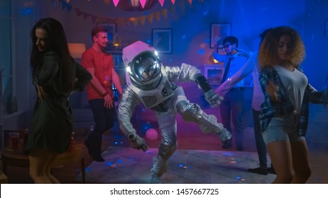 At The College House Costume Party: Fun Guy Wearing Space Suit Dances Off, Doing Robot Dance Modern Moves. With Him Beautiful Girls And Boys Dancing In Neon Lights.