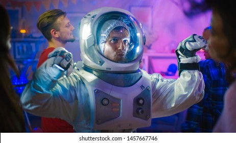 At The College House Costume Party: Fun Guy Wearing Space Suit Dances Off, Doing Robot Dance Modern Moves. With Him Beautiful Girls And Boys Dancing In Neon Lights.