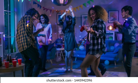 At the College House Party: Diverse Group of Friends Have Fun, Dancing and Socializing. Boys and Girls Dance in the Circle. Disco Neon Strobe Lights Illuminating Room. - Shutterstock ID 1445942396