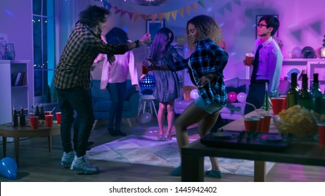 At The College House Party: Diverse Group Of Friends Have Fun, Dancing And Socializing. Boys And Girls Dance In The Circle. Disco Neon Strobe Lights Illuminating Room.