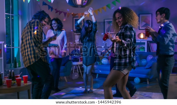 At the College House\
Party: Diverse Group of Friends Have Fun, Dancing and Socializing.\
Boys and Girls Dance in the Circle. Disco Neon Strobe Lights\
Illuminating Room.