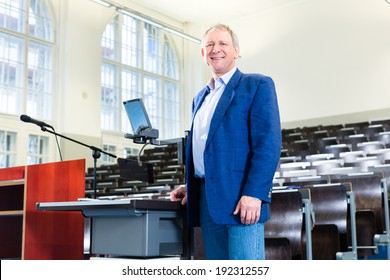 College Professor Giving Lecture And Standing At Desk