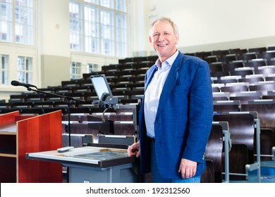 College Professor Giving Lecture And Standing At Desk