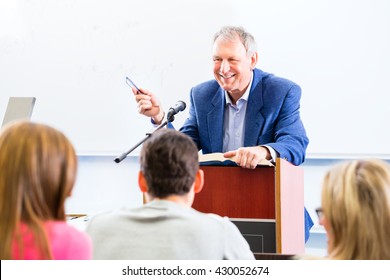 College Professor Giving Lecture For Students Standing At Desk