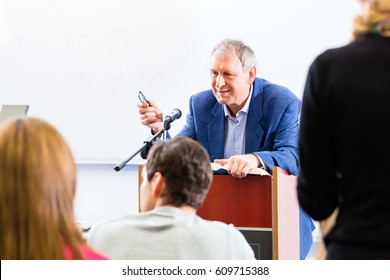 College Professor Giving Lecture For Students Standing At Desk