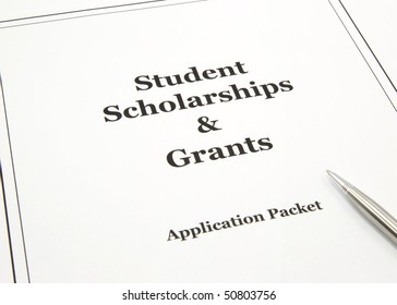 A College Scholarship And Grant Application Packet With A Pen Ready To Start.