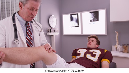 College Sports Athlete With Mid Aged Doctor Examining Knee Injury.