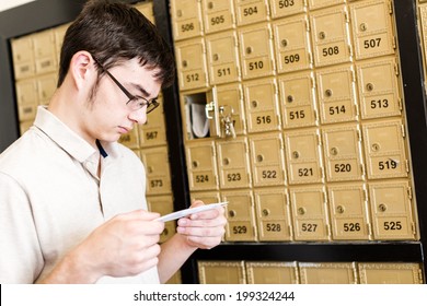 College Student Checking Mail At Mailboxed.