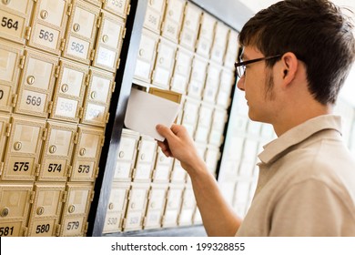 College Student Checking Mail At Mailboxed.