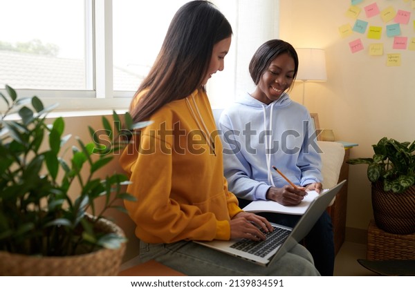 College student explaining diffucult\
topic to friend when they are sitting in dormitory\
room