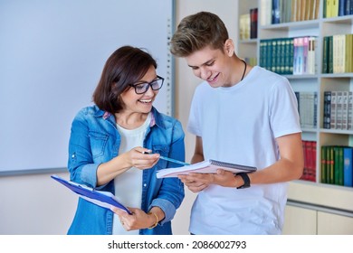 College Student Guy Teenager Meeting Discussing With Teacher Mentor In Classroom