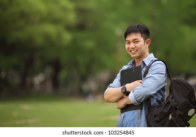 College Student Holding Book On The Park