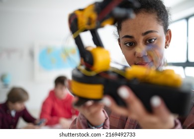 College Student Holding Her Robotic Toy At Robotics Classroom At School.