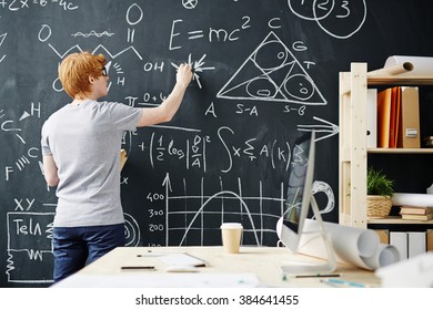 College Student Writing On The Chalkboard During A Math Class