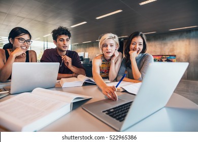 College students using laptop while sitting at table. Group study for school assignment. - Shutterstock ID 522965386