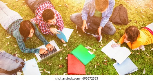 College students using laptop while doing homework at park - Shutterstock ID 695672533