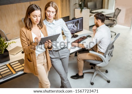 Collegues having some creative work using digital tablet and pencil at the modern office studio. Concept of digital designing on a tablet