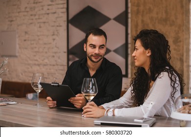 Collegues sprending time together, drinking wine and talking - Shutterstock ID 580303720