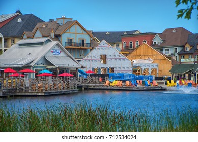 COLLINGWOOD, ON, CANADA - JULY 19, 2017: View of businesses and restaurants by a recreational pond at Blue Mountain Village, Ontario's only four season mountain resort.