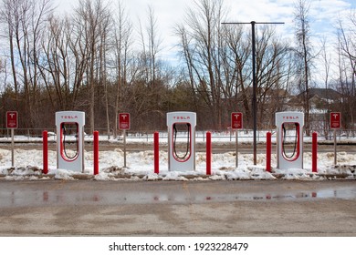 Collingwood, Ontario, Canada - 02-23-2021: Brand new Tesla EV electric car charging Supercharger stations line the parking lot at the Cranberry Mews strip mall close to Blue Mountain 