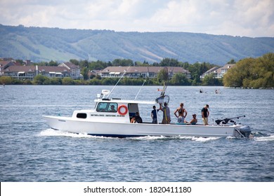 Collingwood, Ontario / Canada - August 22nd: A local Fishing Charter boat returns to the Collingwood harbour with a group of tourists. You can see Blue Mountain Ski resort in the background. 