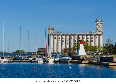 COLLINGWOOD, ONTARIO -  MAY 28, 2014: Old 100ft tall de-commissioned storage terminals looms over the Collingwood harbor on Georgian Bay with many leisure boats