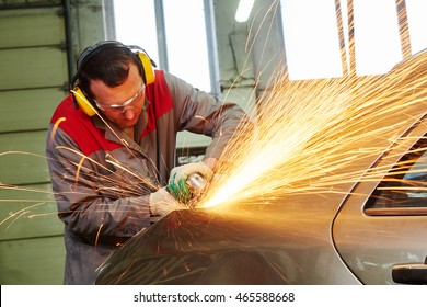 collision repairs service. mechanic grinding car body by grinder - Powered by Shutterstock