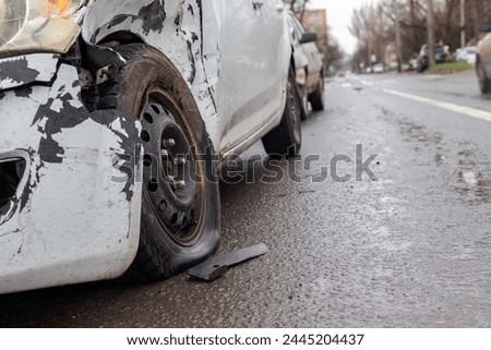 Collision of two white cars. Emphasis on the photo on the flat tire of one of the cars