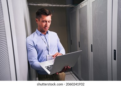 Colocation center employee entering data into laptop