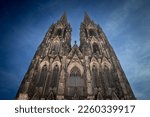 Cologne Cathedral seen from below with blue sky. Cologne Cathedral, or Kolner Dom, is the main landmark of Cologne and a catholic church in Germany.

