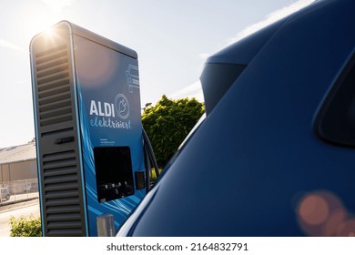 Cologne, Germany, March 2022: Aldi Supercharger or hypercharger for free electric car loading, battery charging station, alternative energy concept. Aldi is a supermarket chains with 10,000 stores.