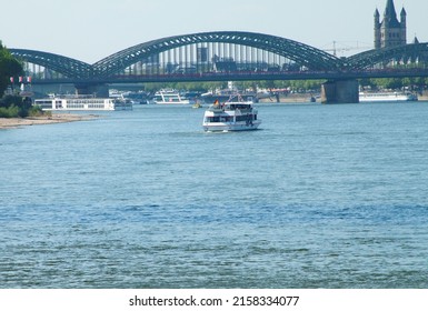 COLOGNE, GERMANY - May 11, 2022: A tourist boat on Rhine river with a bridge in the background in Koln, Germany