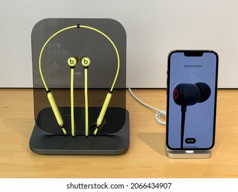 Cologne, Germany - October 28th 2021: A german photographer visiting an apple store, comparing different beats in-ear headphones for his iPhone.